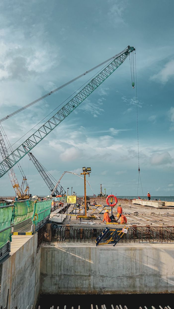 Elevated view of a construction site with cranes under a cloudy sky in West Java, Indonesia.