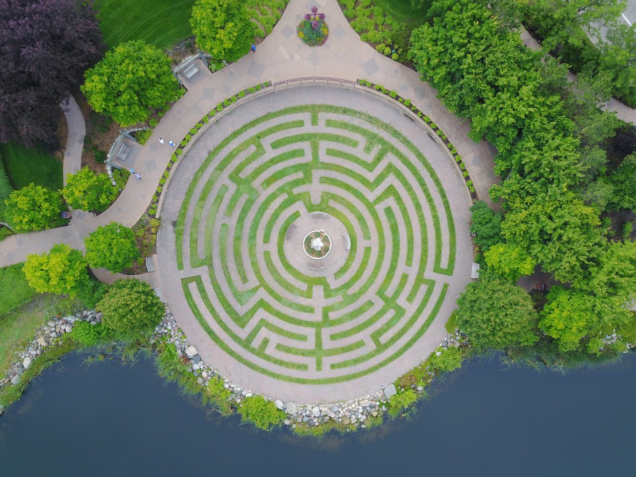 The Art of Drawing Readers In: Your attractive post title goes here Discover an aerial perspective of a circular garden maze surrounded by greenery and water.